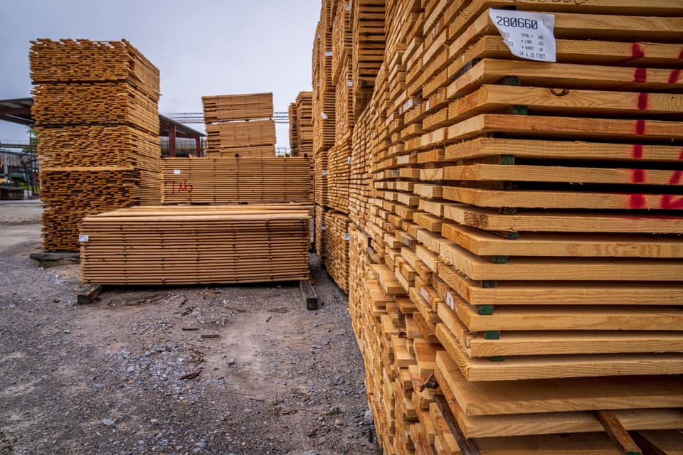 Bundles of graded fence timber stacked in a supply yard.