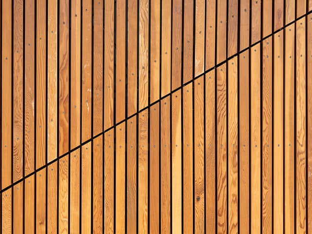 Closely spaced vertical timber slats forming a solid screen.